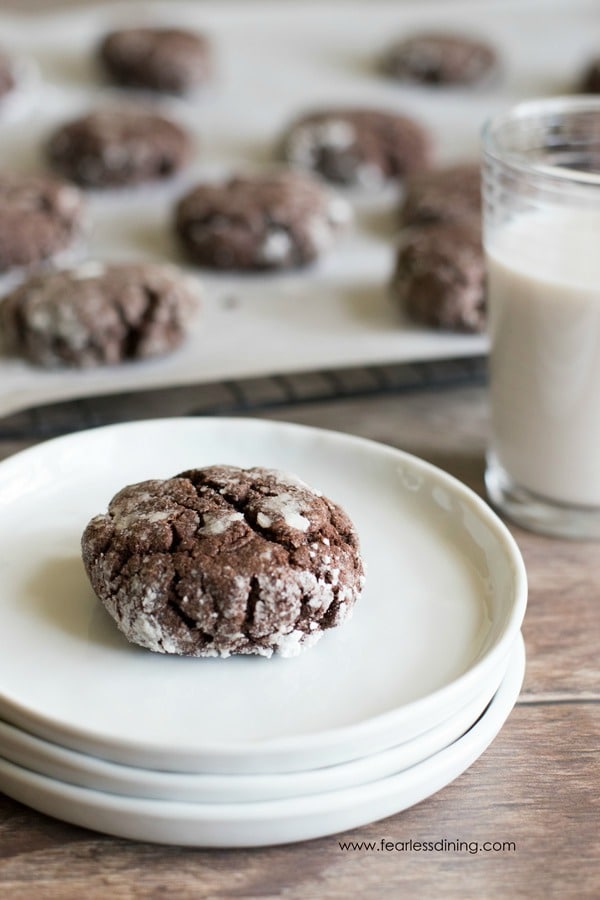 a brookies cookie on a stack of white plates. A glass of milk is next to the stack.