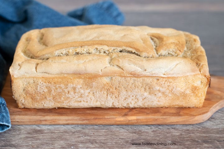 a loaf of gluten free sourdough bread on a cutting board ready to slice.