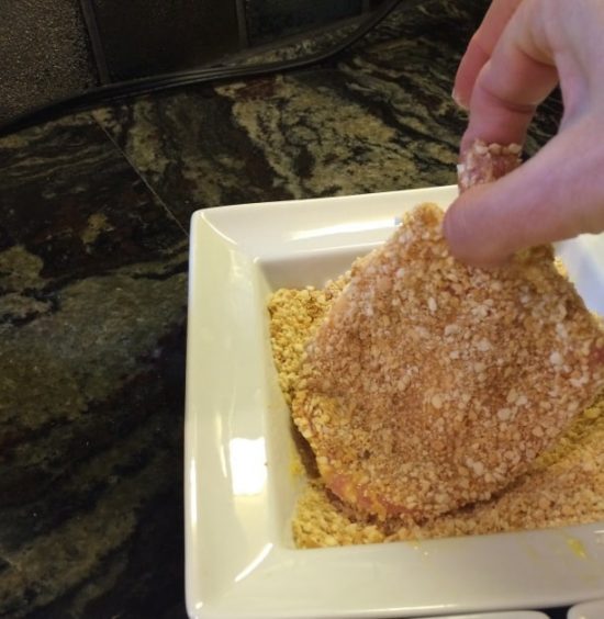 Dipping the pork cutlet into gluten free bread crumbs