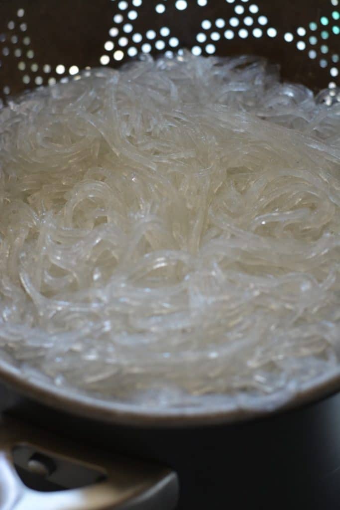 Cooked mung bean noodles in a colander.