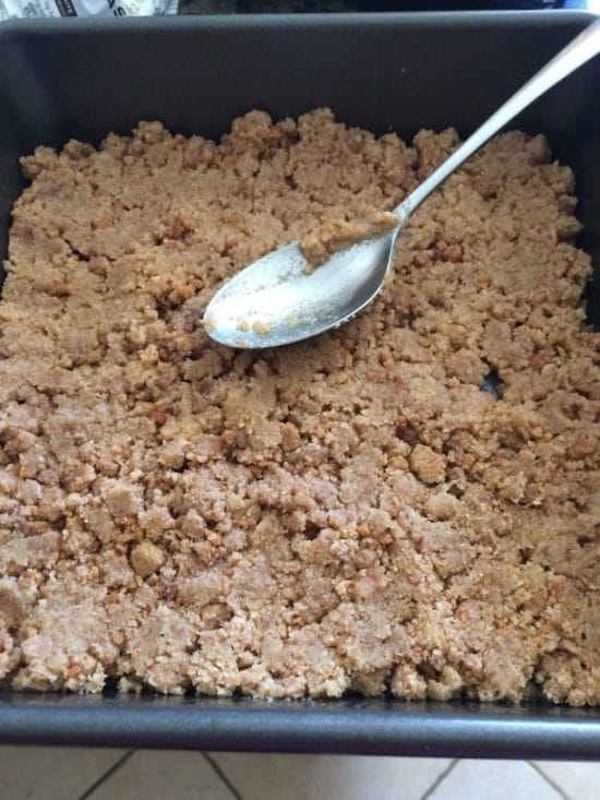 pressing down the graham cracker crust in the baking dish.