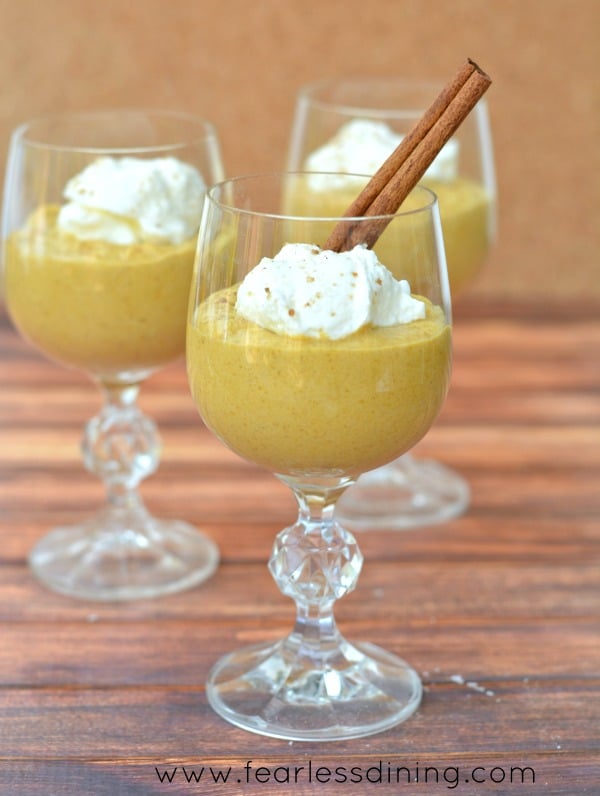 Three glasses of kabocha squash mousse topped with whipped cream