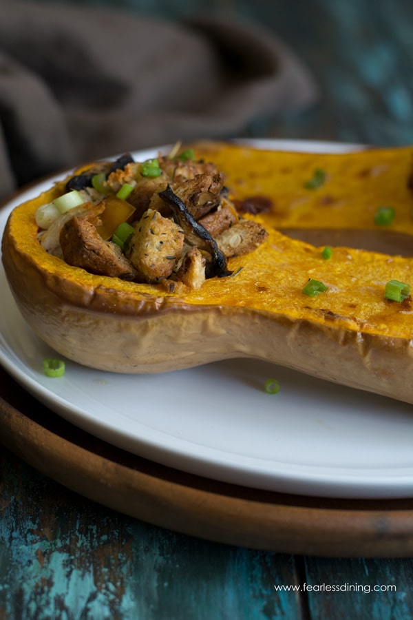 Side view of a half of roasted butternut squash filled with stuffing and turkey