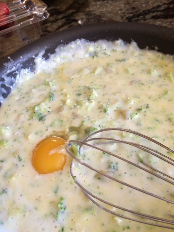 Adding egg yolks to the souffle batter.