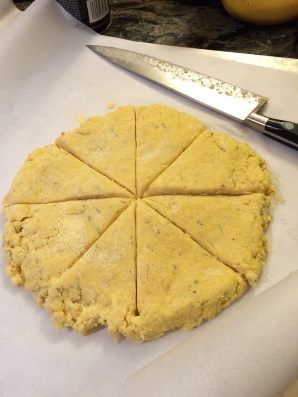 Cut raw scone dough on a cutting board.