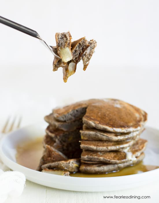 A fork holding up a bite of the gluten free buckwheat pancakes.