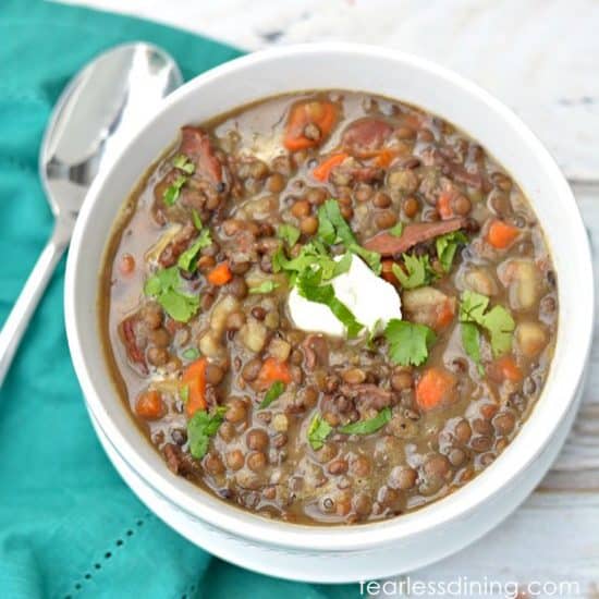A bowl of lentil bacon soup on a table.