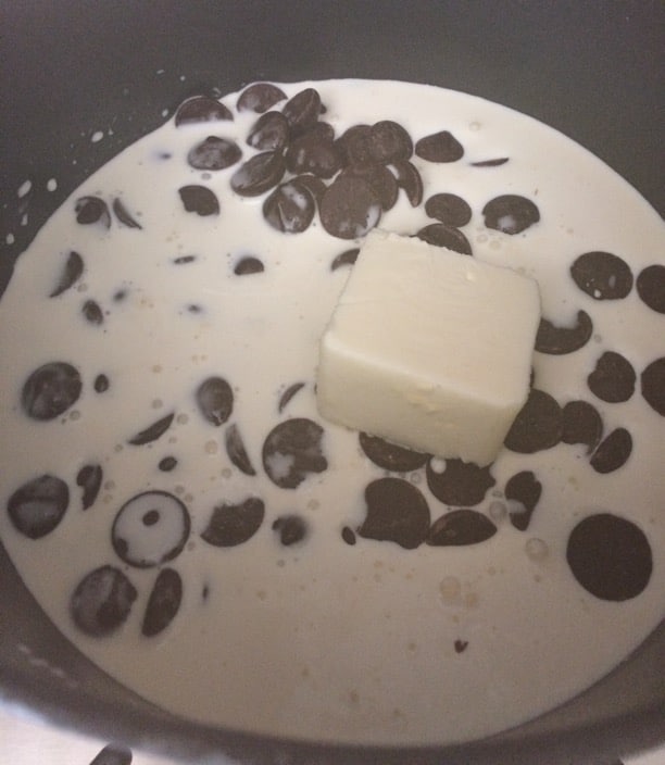 A saucepan with heavy cream, chocolate, and butter.