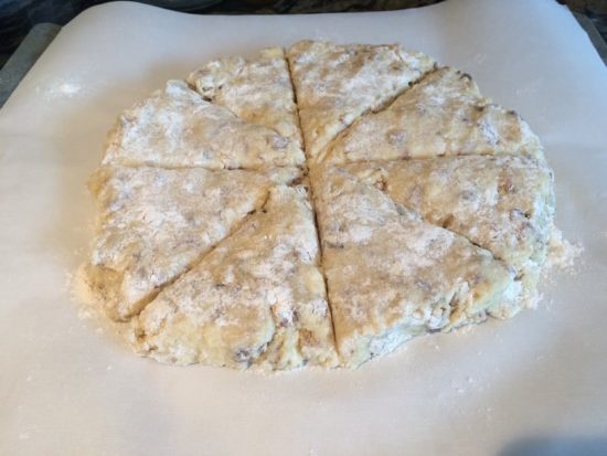 a round of scone dough on parchment paper, cut into wedges