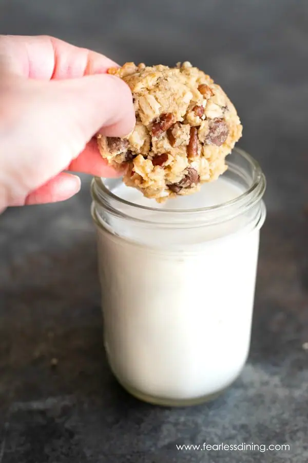 dipping a cowboy cookie into a glass of milk.