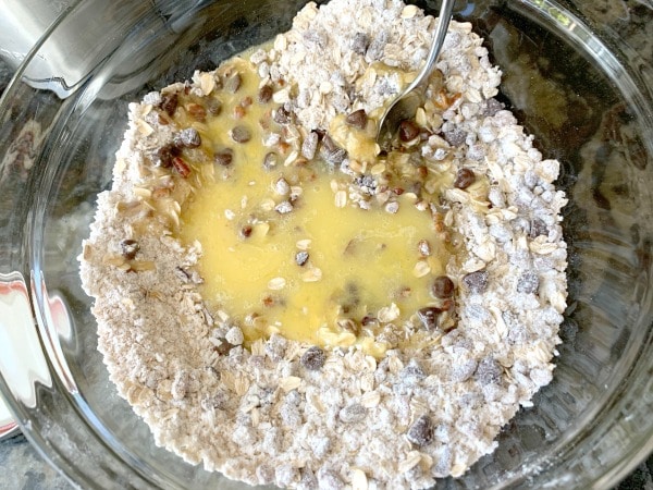 Wet and dry cowboy cookie ingredients in a bowl.