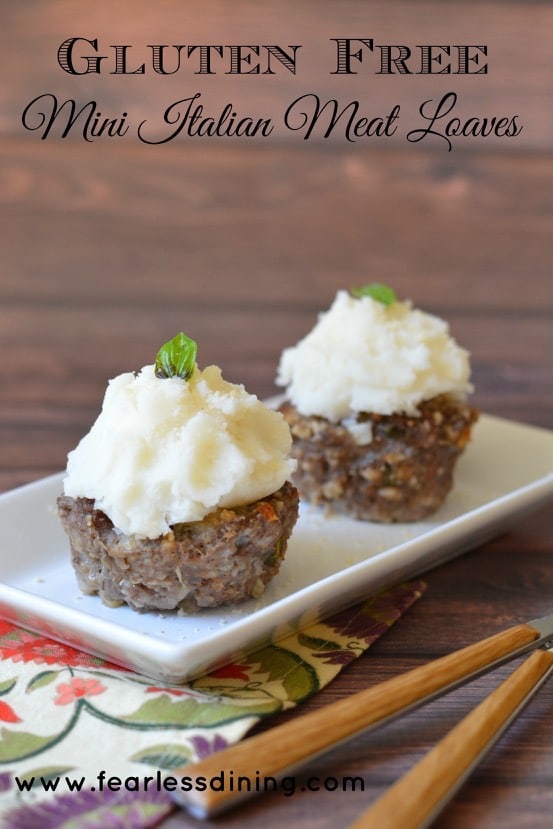 These mini Italian gluten free meat loaves on a platter. Mashed potatoes are piled on top of the meatloaves so they look like cupcakes