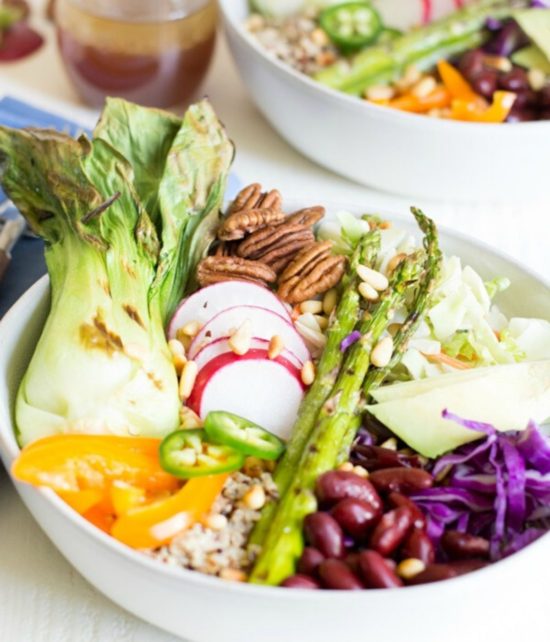 A Buddha bowl filled with bok choy and other roasted veggies and grains.