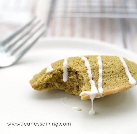 A single Gluten Free Matcha Madeleine on a plate with a bite taken out.