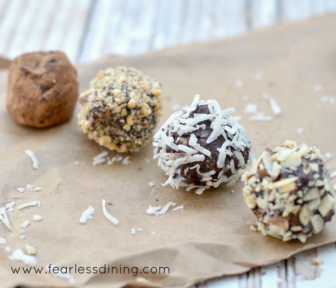 Four chocolate truffles on a paper bag.