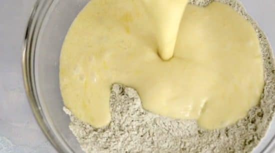 Pouring wet ingredients into the dry ingredients.