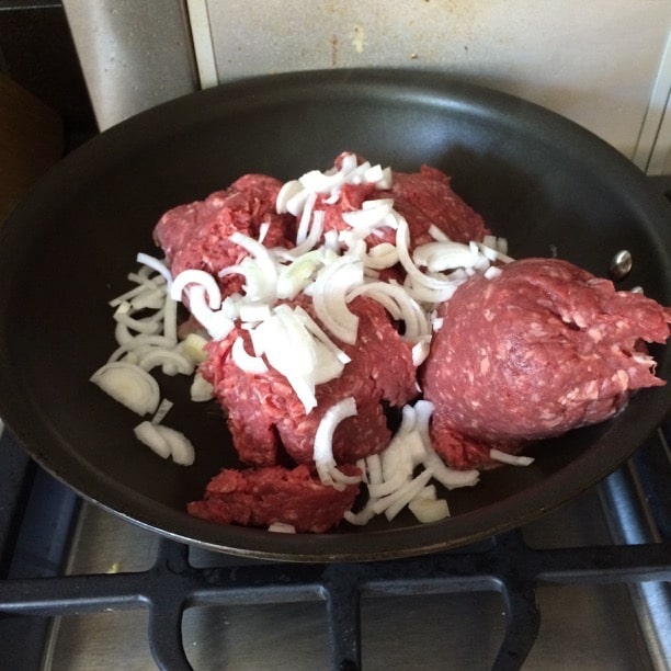 Cooking ground beef with onions in a skillet.