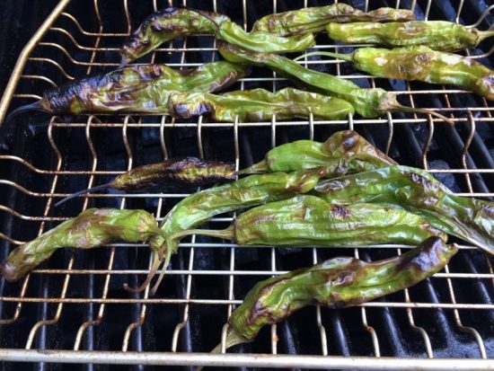 A grill basket with peppers.