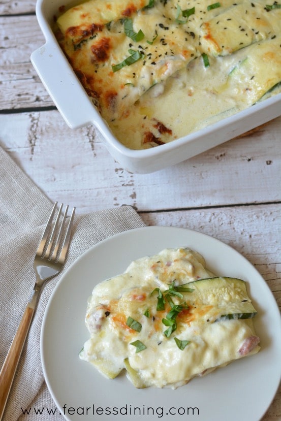 Super Cheesy Zucchini Lasagna Alfredo on a plate. The casserole dish is in the background.