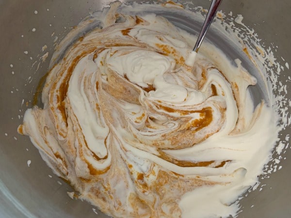 The mixing gently the pumpkin and whipped cream.