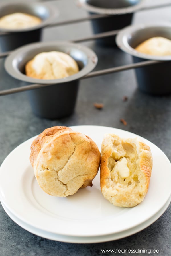 A gluten free popover on a plate. One popover is cut in half.