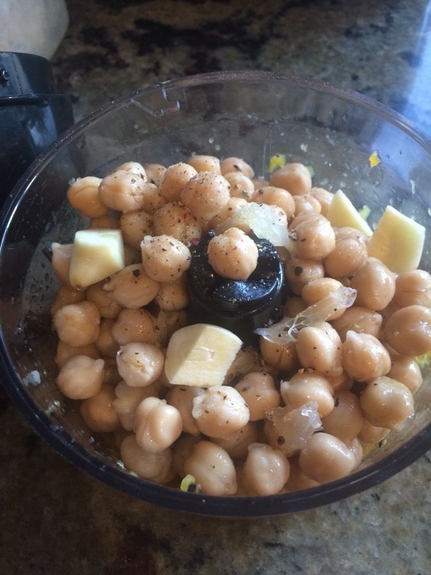 Adding garbanzo beans to the food processor.