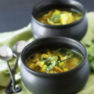 black soup crocks filled with comforting tumeric vegetable soup