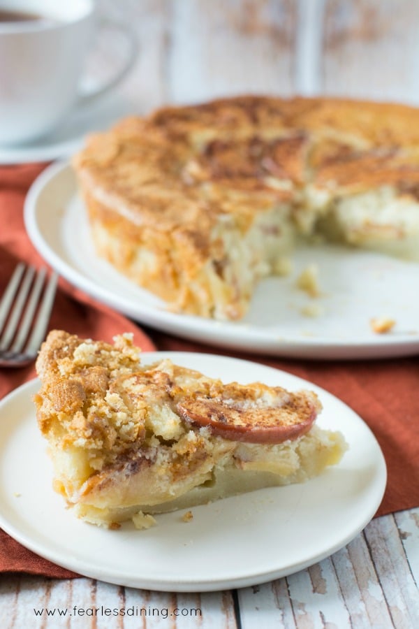 A slice of gluten free apple cake on a small white plate.