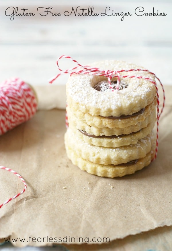 a stack of gluten free linzer cookies tied with baker's string