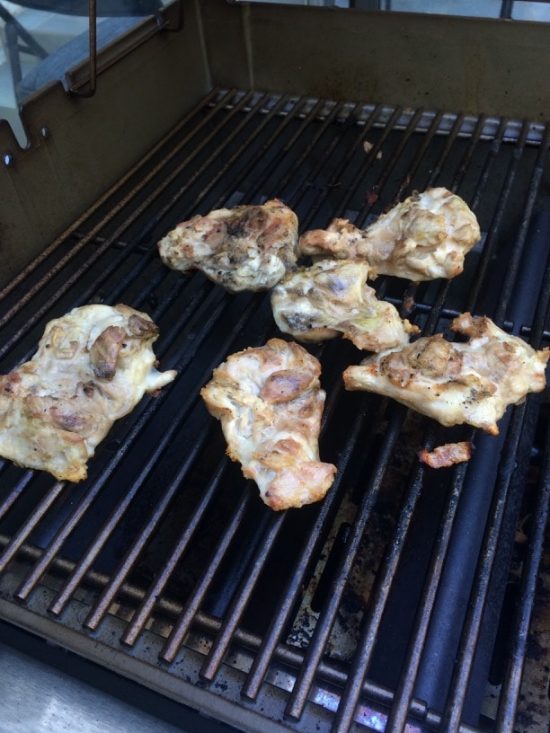 Chicken thighs cooking on the grill.