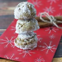 A stack of three pfeffernusse cookies on a Christmas bag.