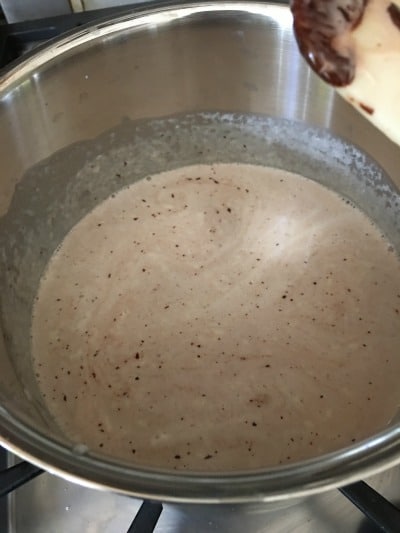 Melting dark chocolate into cream to make gluten free chocolate custard.