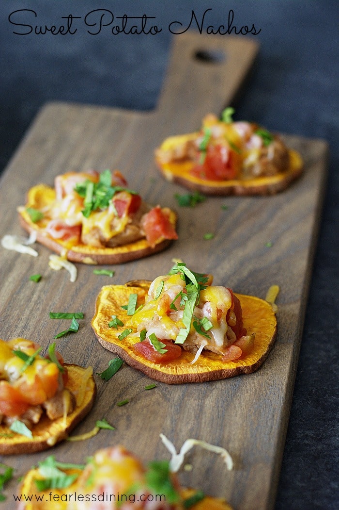 Baked sweet potato nachos on a wooden serving dish.