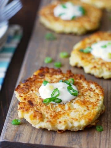 Gluten Free Cauliflower Pancakes made with riced cauliflower, topped with sour cream and scallions