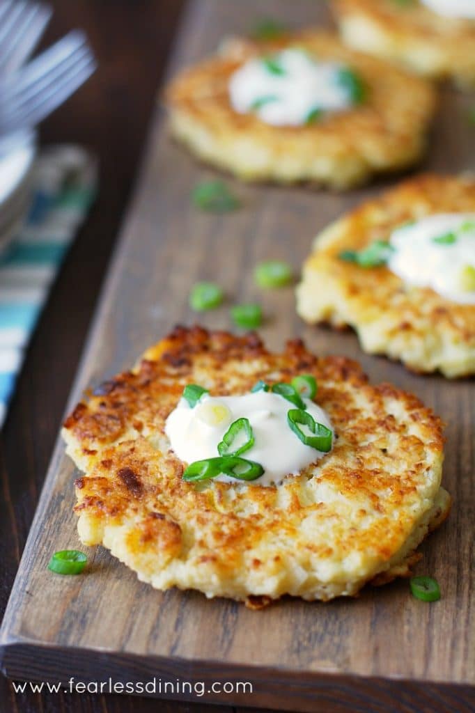 Top view of Gluten Free Cauliflower Cheddar Pancakes on a wooden cutting board.