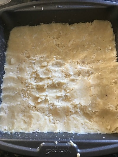 Lime Bar crust is spread out in a baking pan.