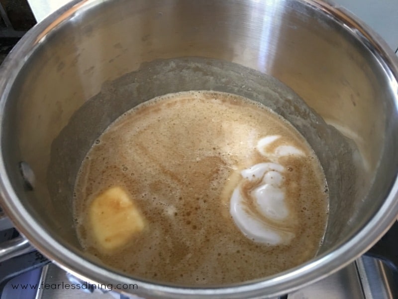 The caramel sauce ingredients cooking in a pot.