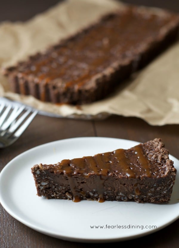 Gluten Free Chocolate Caramel Tart slice on a plate.