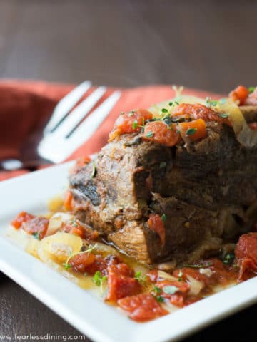 a platter with a large pot roast on it