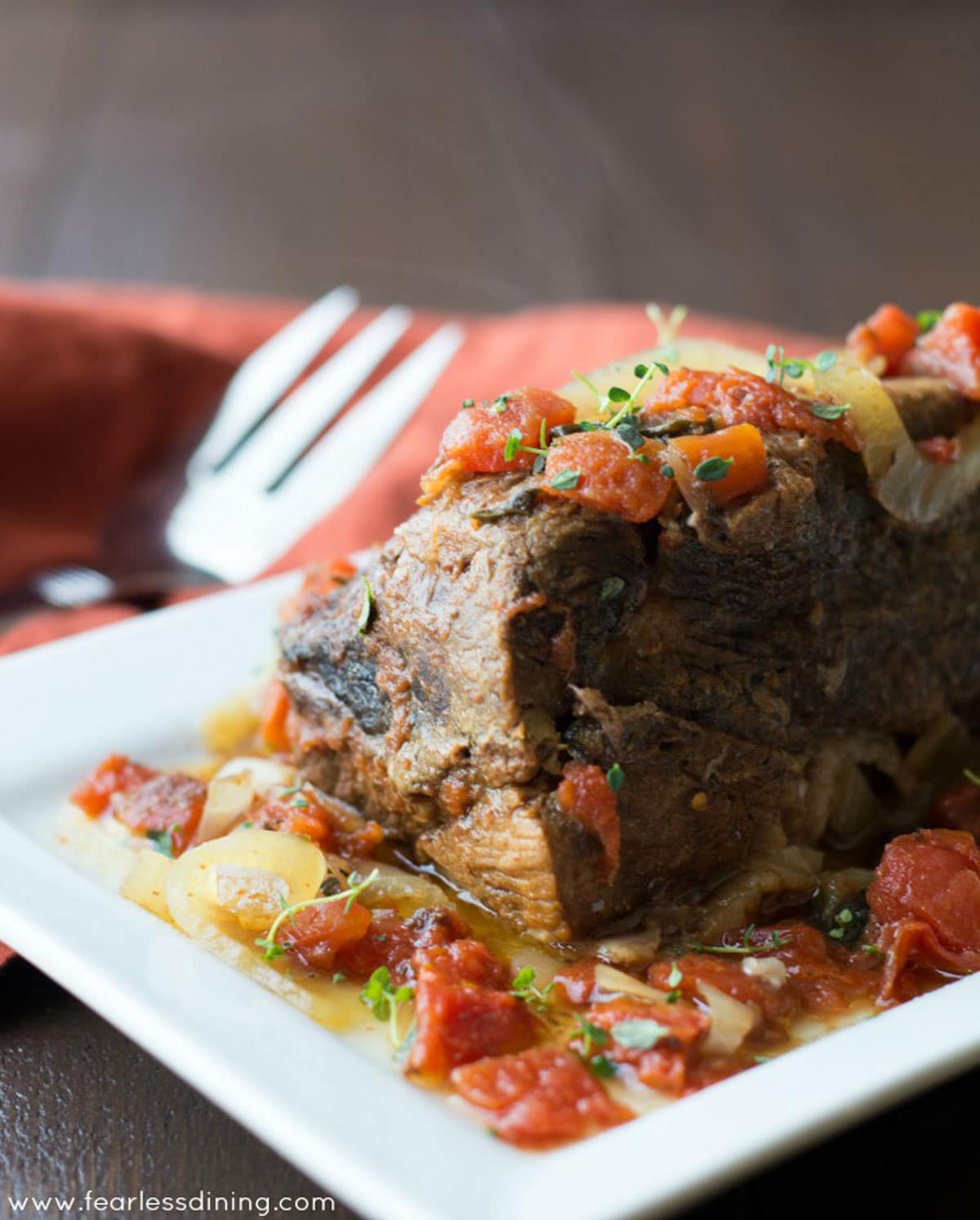 A large platter with a large pot roast on it.