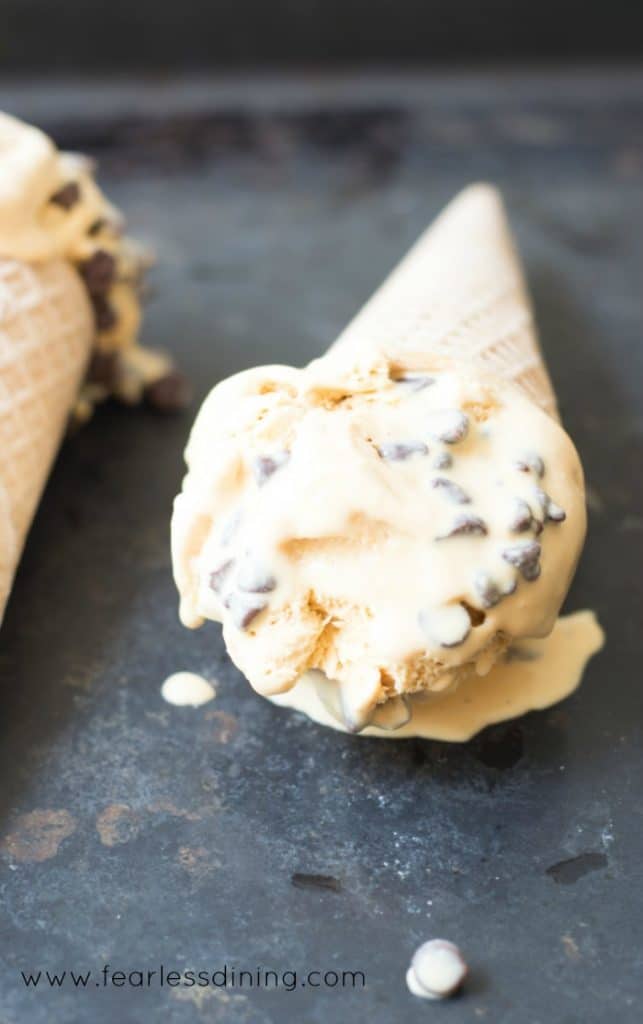A cone of homemade Caramel Ice Cream with chocolate chips on a tray.