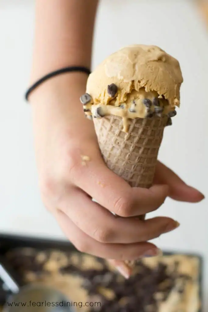 A hand holding a cone of No-Churn Caramel Chip Ice cream.
