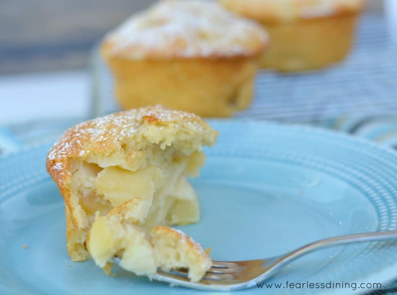 Gluten Free French Apple Cake partially eaten sitting on a blue plate. A fork is holding a piece of the apple cake.