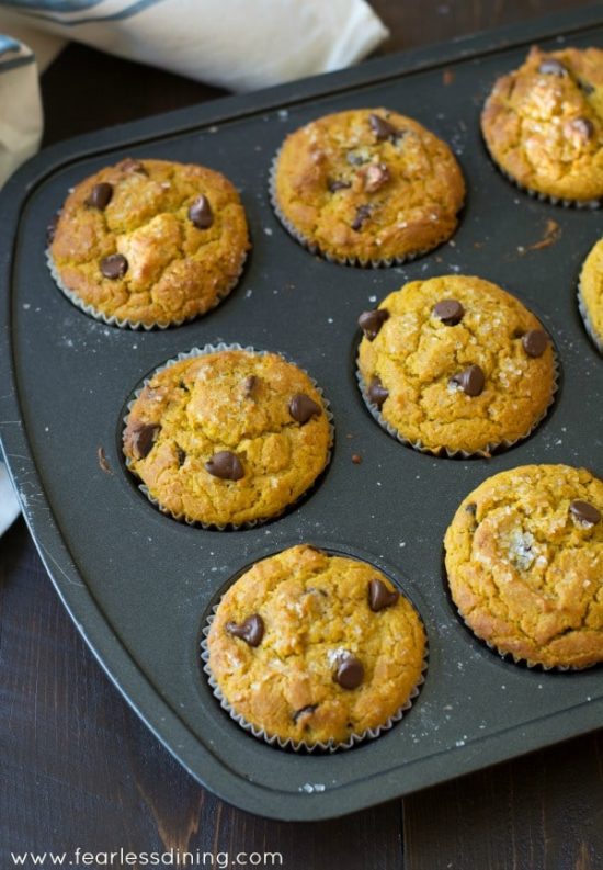 A muffin pan filled with baked gluten free pumpkin muffins.