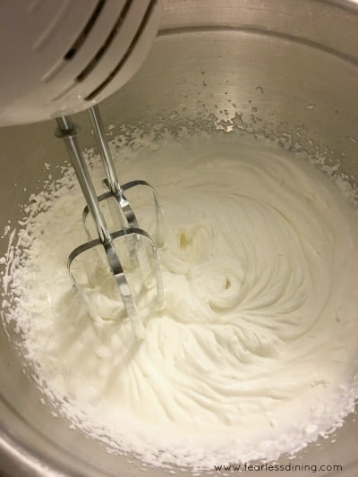 A mixer whipping cream in a bowl