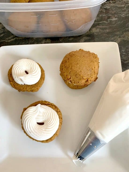 Filling whoopie pies with vanilla frosting.