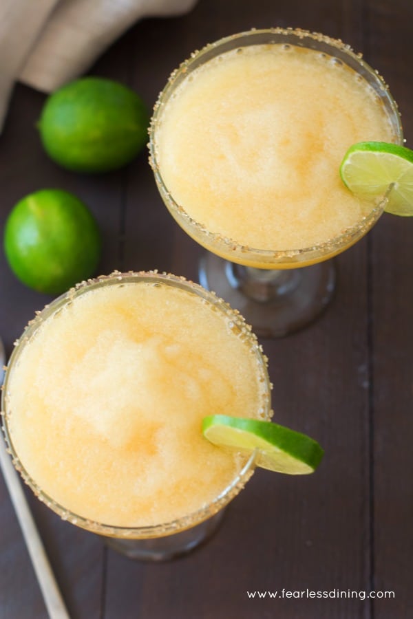 Top view of two glasses of frozen peach margaritas.