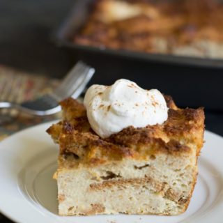 A slice of eggnog bread pudding on a white plate.