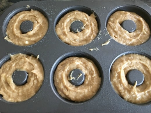 Gluten free banana batter in a donut pan ready to bake.