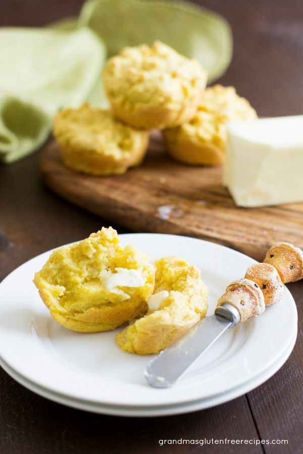 A gluten free cornbread muffin cut open on a plate.